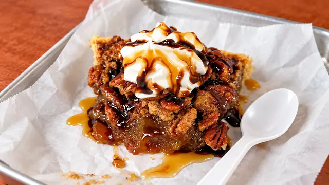 Pecan dessert with whipped cream and caramel sauce