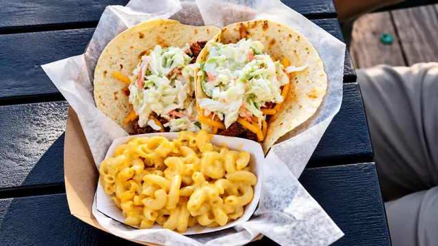 Soft tacos topped with slaw and a side of macaroni and cheese